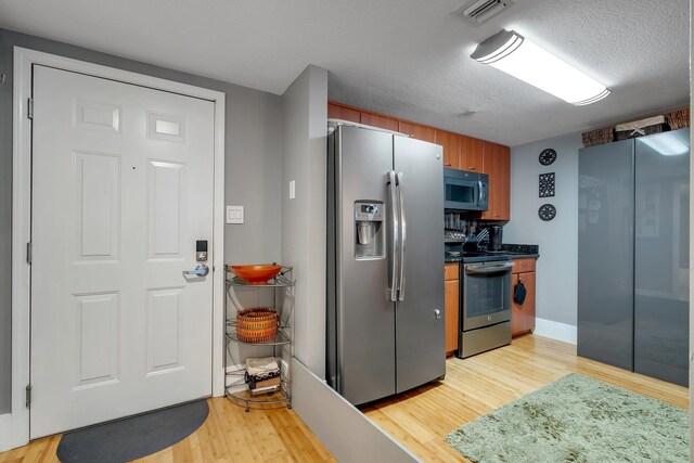 300 S Duval St # 508, Tallahassee, FL 32301 - kitchen with stainless steel appliances, light wood-style floors, dark countertops, and a textured ceiling