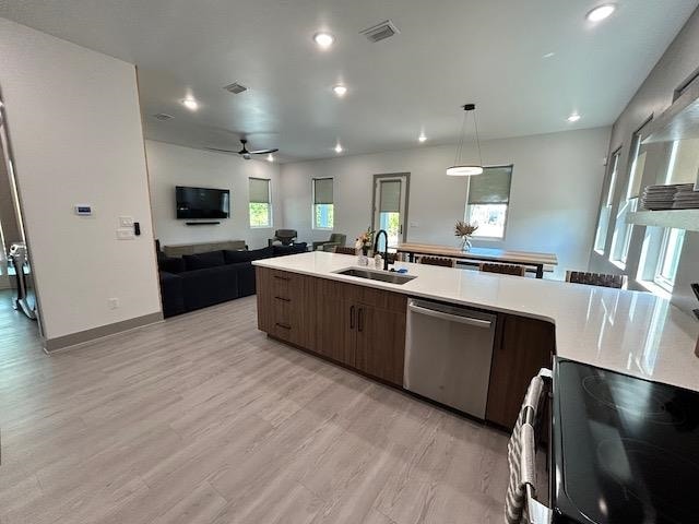 kitchen with dark brown cabinets, light hardwood / wood-style flooring, stainless steel dishwasher, and sink