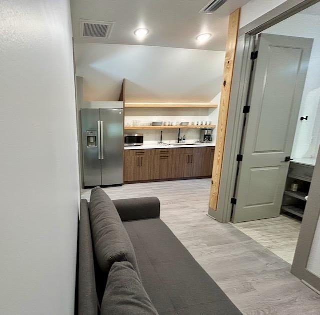 kitchen with appliances with stainless steel finishes, light hardwood / wood-style flooring, and sink