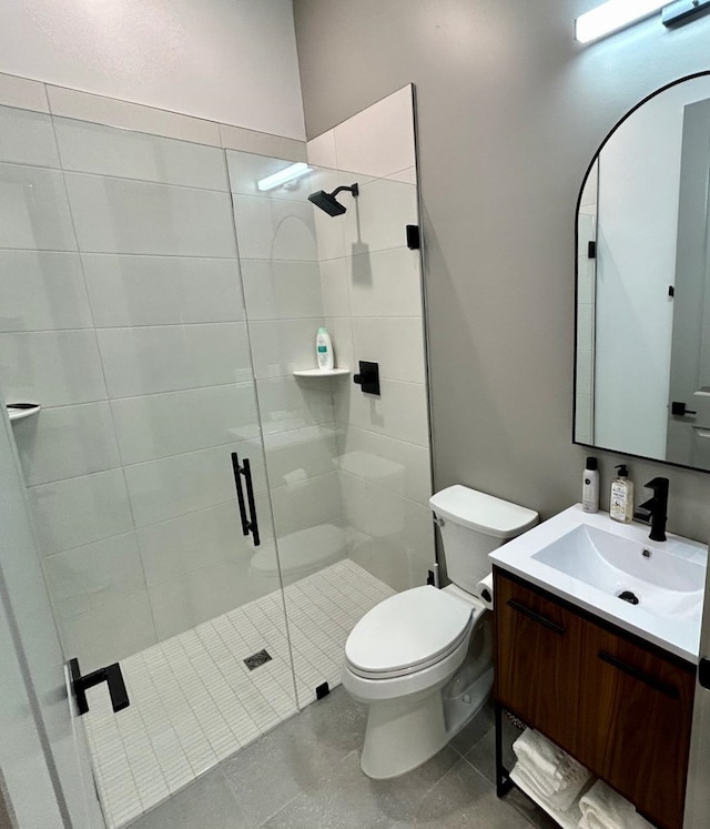 bathroom with tile patterned flooring, a shower with door, vanity, and toilet