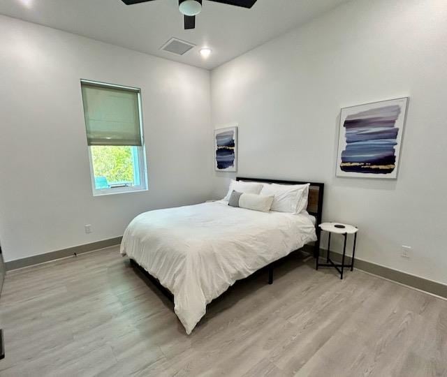 bedroom with light hardwood / wood-style flooring and ceiling fan