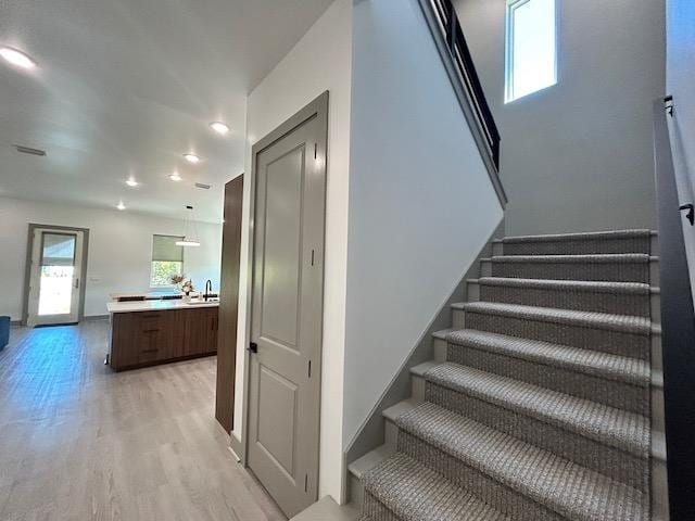 stairs with wood-type flooring and sink