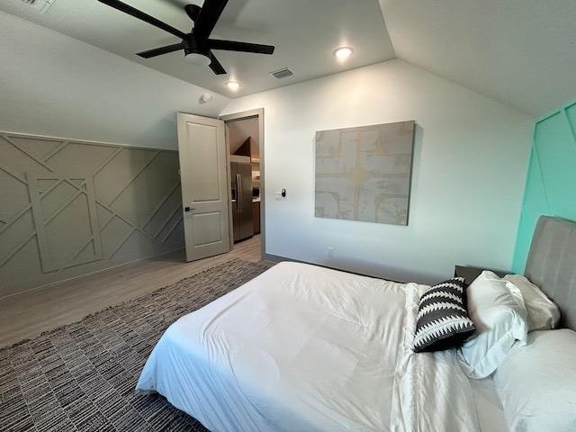 bedroom featuring ceiling fan, vaulted ceiling, and hardwood / wood-style flooring