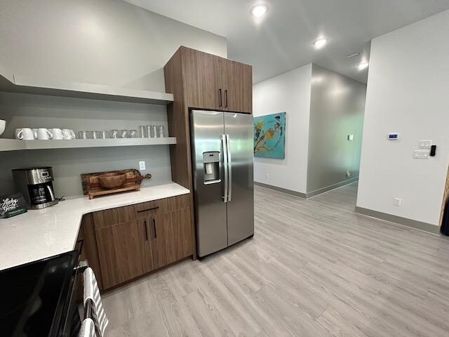 kitchen featuring stainless steel fridge, stove, and light hardwood / wood-style floors