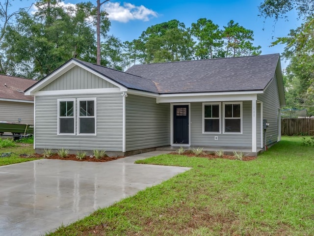 45 Sioux Trl, Crawfordville, FL 32327 - view of front facade featuring a shingled roof, a front yard, board and batten siding, and a patio area