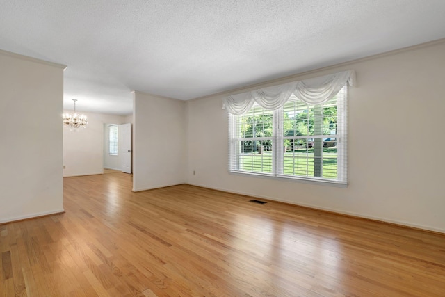 3024 S Shamrock, Tallahassee, FL 32309 - unfurnished room with visible vents, baseboards, a notable chandelier, ornamental molding, and light wood-style flooring