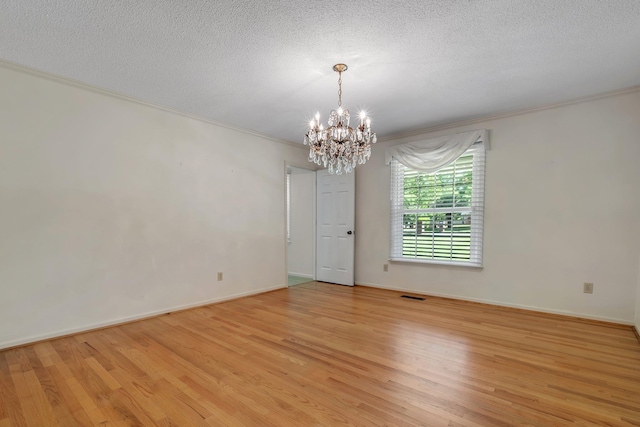 3024 S Shamrock, Tallahassee, FL 32309 - empty room with crown molding, an inviting chandelier, visible vents, and light wood-style floors