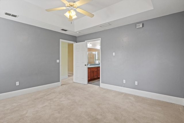 3770 Laurel Trace Way, Tallahassee, FL 32303 - unfurnished bedroom featuring light carpet, baseboards, connected bathroom, and a tray ceiling