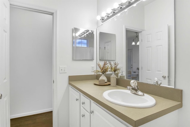 bathroom with vanity, baseboards, and wood finished floors