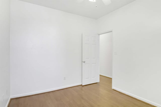 empty room with baseboards, wood finished floors, and a ceiling fan