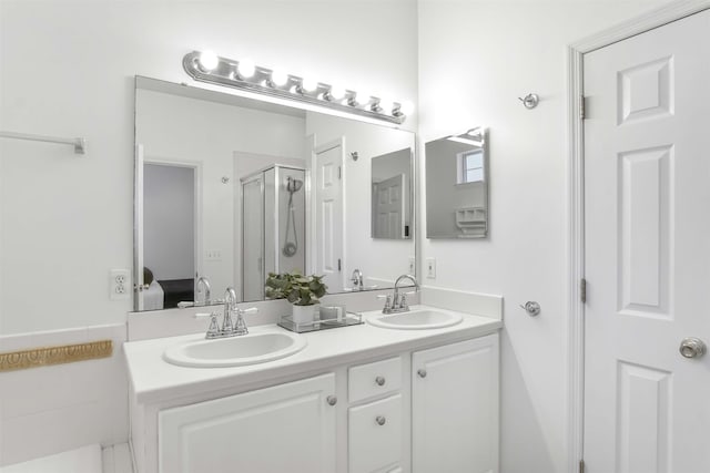 bathroom with double vanity, a stall shower, and a sink