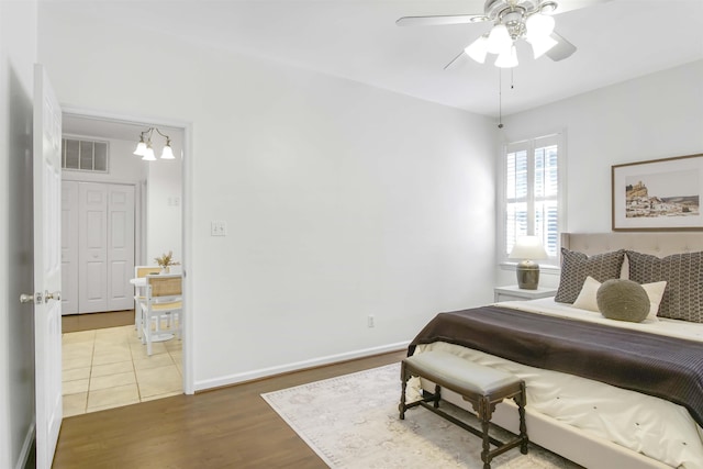 bedroom with visible vents, ceiling fan, baseboards, and wood finished floors