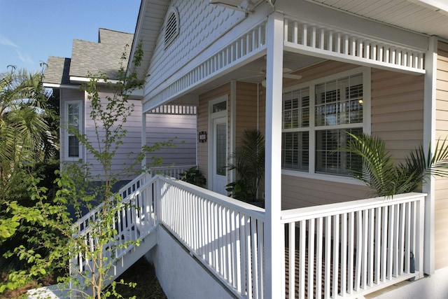 view of exterior entry with a porch and a shingled roof