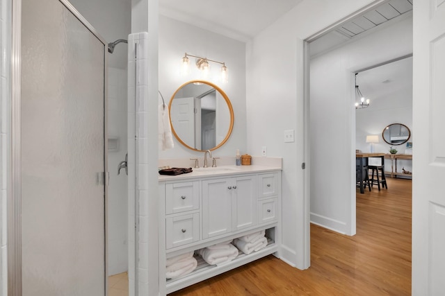 bathroom featuring hardwood / wood-style floors, an enclosed shower, and vanity