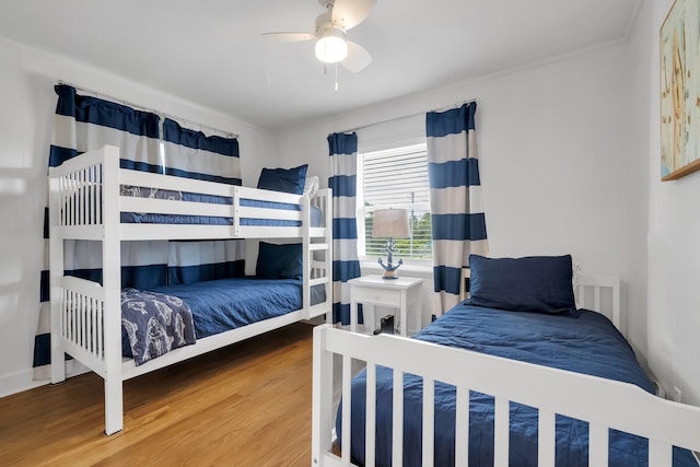 bedroom with hardwood / wood-style floors, ceiling fan, and crown molding