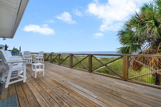 wooden terrace with a water view and a lawn