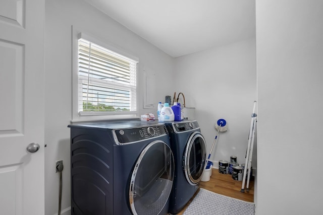 laundry room with washer and clothes dryer and light hardwood / wood-style flooring