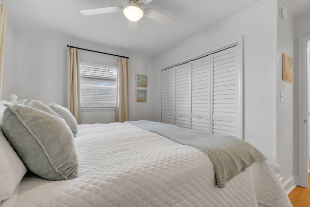 bedroom with light hardwood / wood-style floors, ceiling fan, a closet, and crown molding