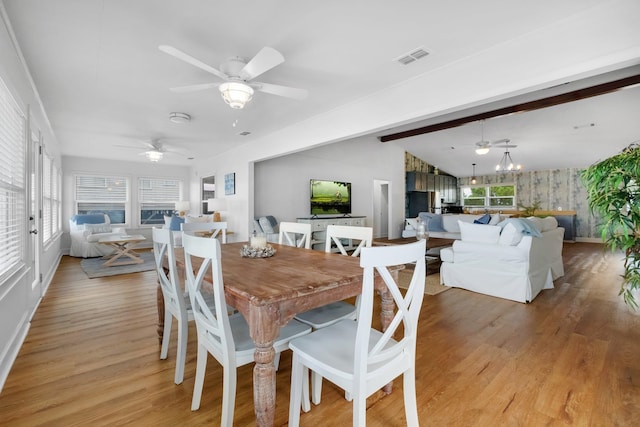 dining area with light wood-type flooring, vaulted ceiling with beams, and ceiling fan with notable chandelier