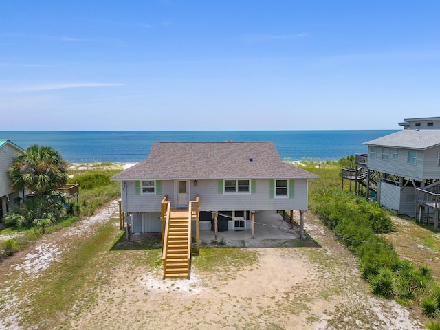 back of property featuring cooling unit, a carport, and a water view