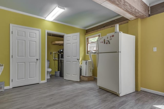 kitchen with light wood-type flooring, a wall unit AC, and white refrigerator