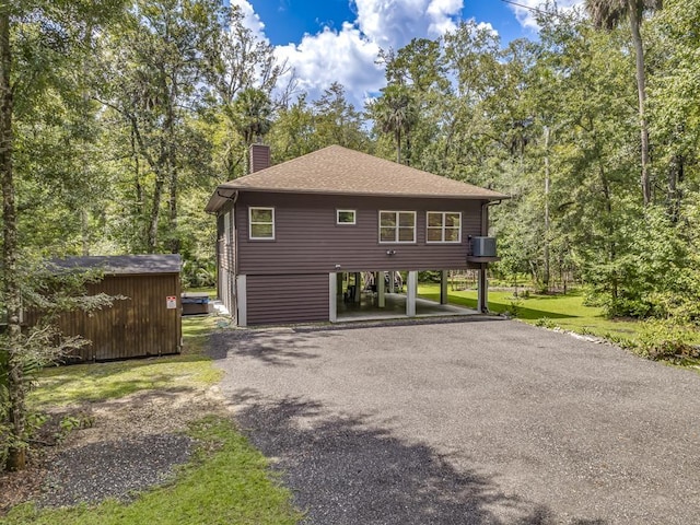 view of side of property featuring a carport and a storage shed