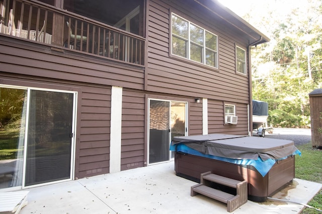 back of house featuring cooling unit, a hot tub, and a patio