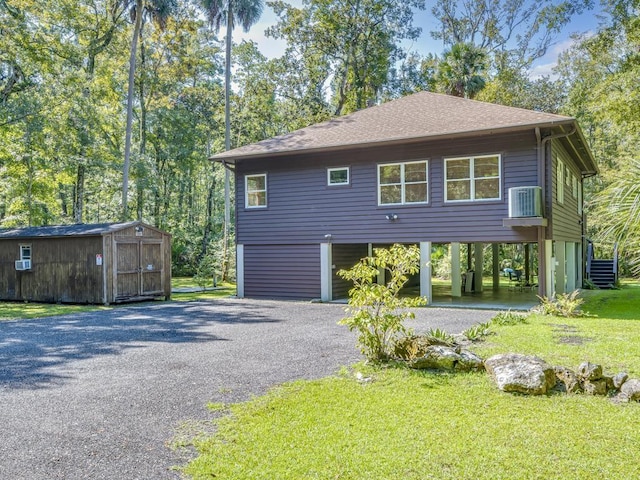 view of side of property with a yard and a shed