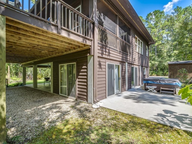 view of property exterior featuring a hot tub and a patio