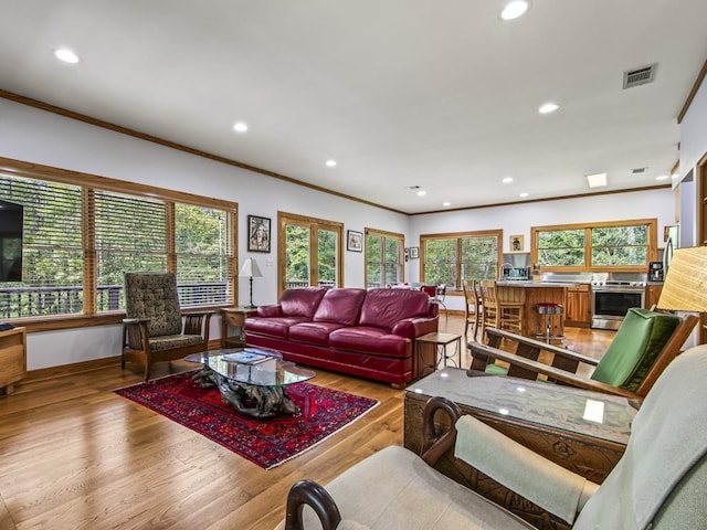 living room featuring crown molding and light wood-type flooring