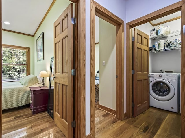 laundry area featuring hardwood / wood-style flooring, ornamental molding, and washer / dryer