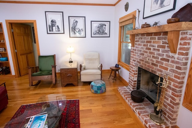 living room with crown molding, hardwood / wood-style floors, and a fireplace