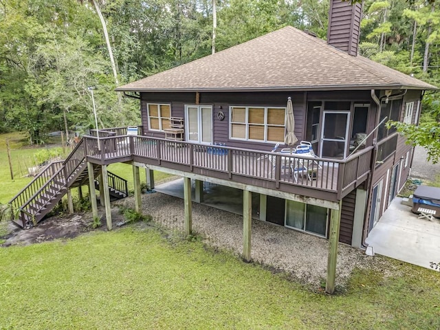 back of property with a wooden deck, a sunroom, and a lawn