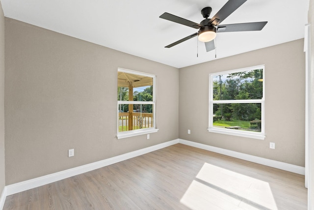 spare room with light hardwood / wood-style flooring, ceiling fan, and plenty of natural light