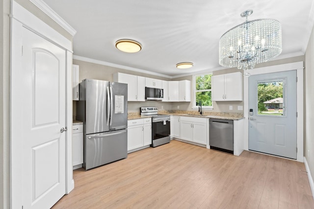 kitchen featuring stainless steel appliances, crown molding, pendant lighting, light hardwood / wood-style flooring, and white cabinetry