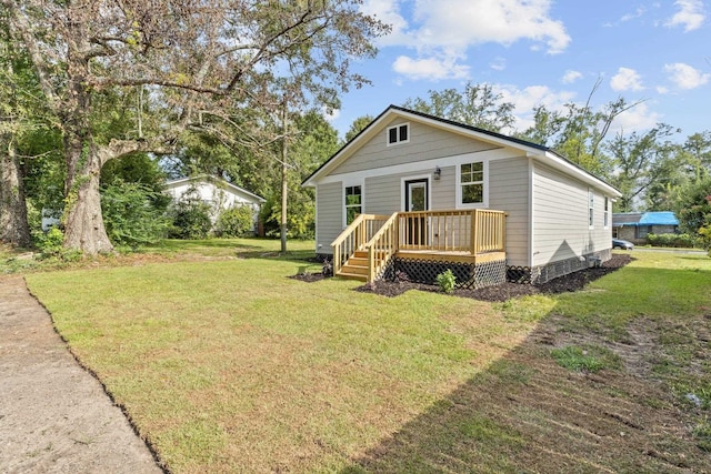 view of front facade with a front yard and a wooden deck