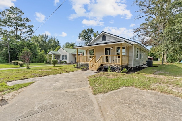 bungalow-style home with central AC unit, a front yard, and covered porch