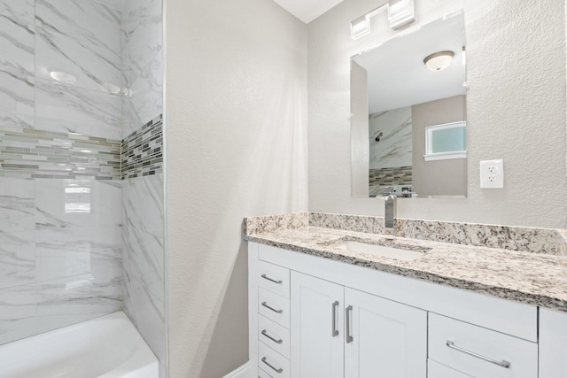 bathroom featuring vanity and tiled shower / bath