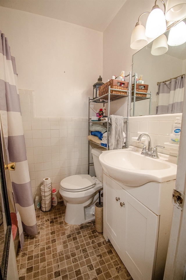 319 Gaile Ave, Tallahassee, FL 32305 - bathroom featuring tile walls, wainscoting, curtained shower, vanity, and toilet