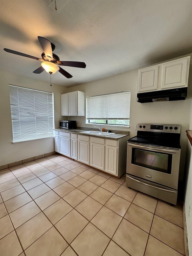 2755 Lake Bradford Rd, Tallahassee, FL 32310 - kitchen featuring appliances with stainless steel finishes, a sink, under cabinet range hood, white cabinetry, and light tile patterned flooring