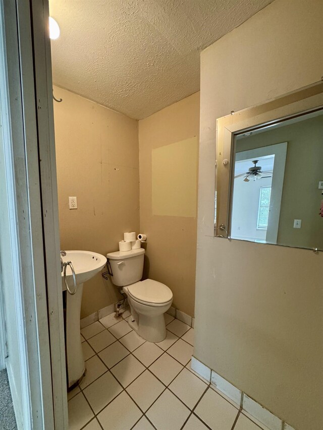 2755 Lake Bradford Rd, Tallahassee, FL 32310 - bathroom featuring a textured ceiling, tile patterned flooring, toilet, baseboards, and a sink