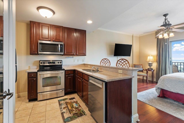 kitchen with kitchen peninsula, stainless steel appliances, light hardwood / wood-style flooring, and ornamental molding