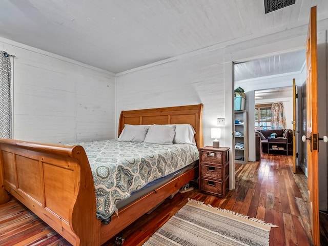 bedroom featuring wood walls and dark hardwood / wood-style flooring