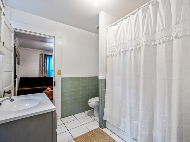 full bathroom featuring tile walls, tile patterned floors, vanity, toilet, and shower / bathtub combination with curtain