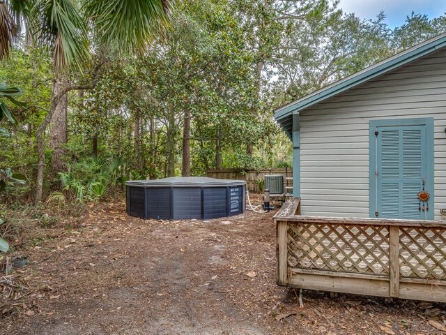 view of yard with central AC and a hot tub