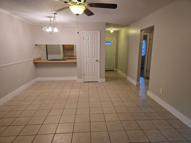 empty room featuring light tile patterned flooring, ceiling fan, and a textured ceiling