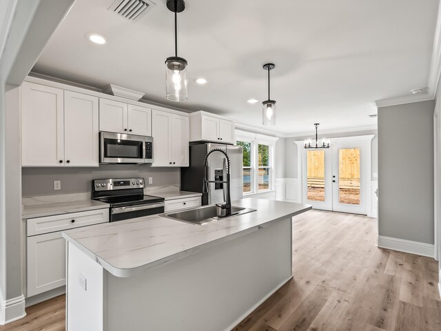 43 Sioux Trl, Crawfordville, FL 32327 - kitchen featuring appliances with stainless steel finishes, ornamental molding, an island with sink, white cabinetry, and light countertops