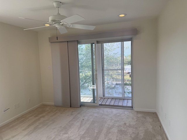 carpeted empty room featuring baseboards and ceiling fan