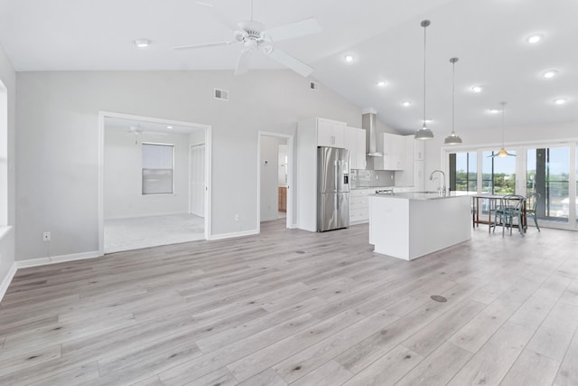 82 Royster Dr, Crawfordville, FL 32327 - kitchen with stainless steel fridge with ice dispenser, ceiling fan, wall chimney range hood, light countertops, and white cabinetry