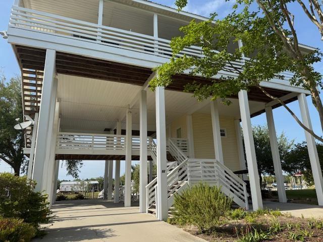 view of community with stairway, a carport, and concrete driveway